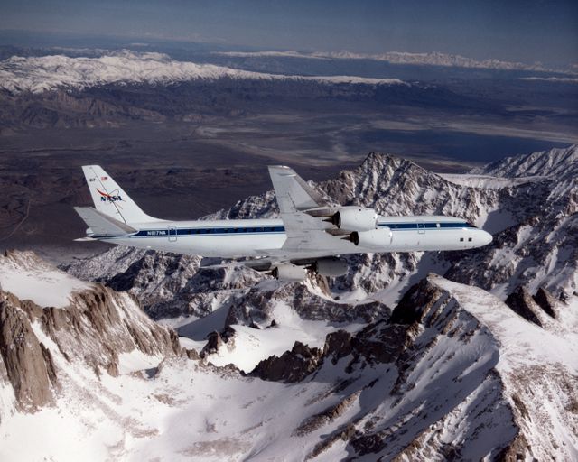 NASA's DC-8 aircraft flying over the jagged, snow-covered peaks of Mount Whitney on February 25, 1998. The aircraft, part of the NASA Dryden Flight Research Center's Airborne Science program, is used for various scientific experiments by NASA, other governmental agencies, academia, and technical organizations. Suitable for content related to aviation, aerospace research, scientific exploration, and natural landscapes.