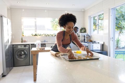 African american couple baking together in bright modern open-plan kitchen