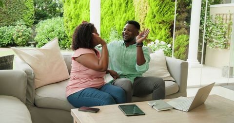 Happy Couple Collaborating with Technology and Documents at Home