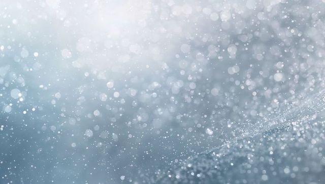 Glittering frost forming crystalline ridge with soft blue bokeh and sparkling droplets