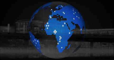 Digital blue pixel globe over cityscape at night