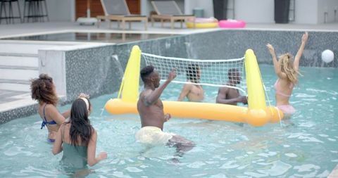 Diverse Friends Playing Pool Volleyball Under Summer Sun
