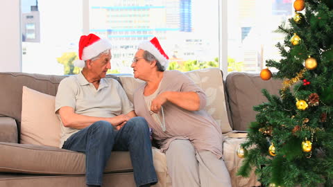 Senior Couple Celebrating Christmas with Santa Hats