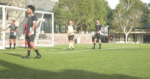 Amateur Soccer Team Practicing Outdoors with Focus on Strategy