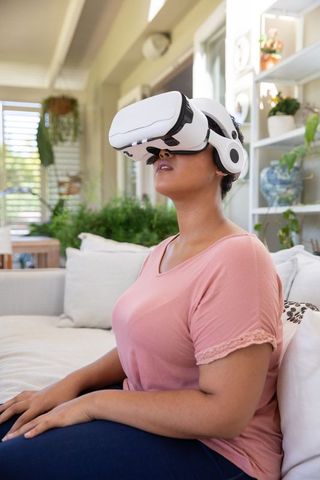 African American Woman Engaging in Virtual Reality Experience at Home