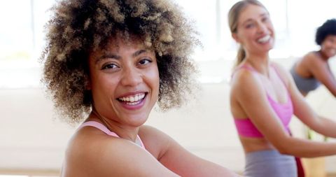 Joyful Women Enjoying Group Yoga Session in Bright Studio