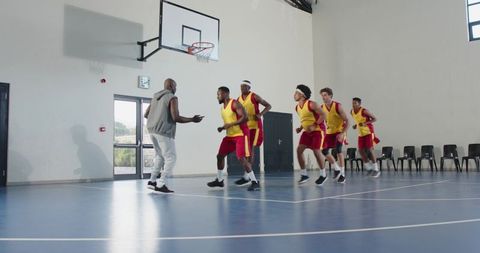 Basketball coach guiding diverse team in training