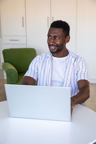 Man Engaged in Remote Work at Home with Laptop