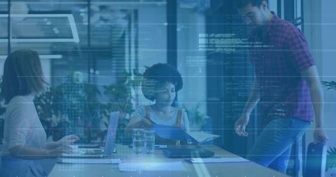 Team collaborating over data reports in modern conference room with laptop and charts