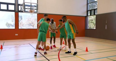 Basketball Team Uniting in Gym for Strategy