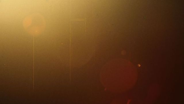 Atmospheric golden glow with red bokeh and light streaks