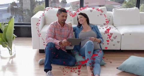 Expecting Couple Reviewing Finances on Tablet in Sunlit Cozy Living Room