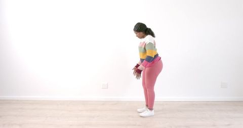 Woman Performing Stretching Exercise in Bright Casual Wear