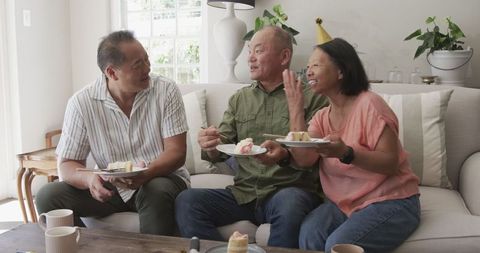 Asian Seniors Sharing Joyful Moments with Cake at Home