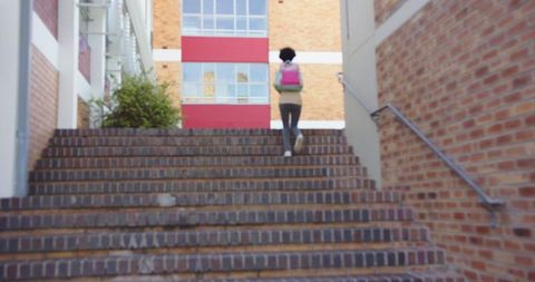 Child Walking Up Brick Stairs with Pink Backpack in Urban Setting