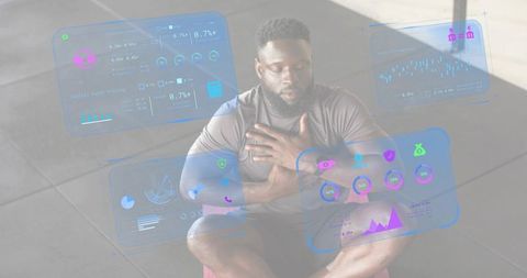 Athlete reviewing augmented reality fitness dashboards during cooldown on gym mat