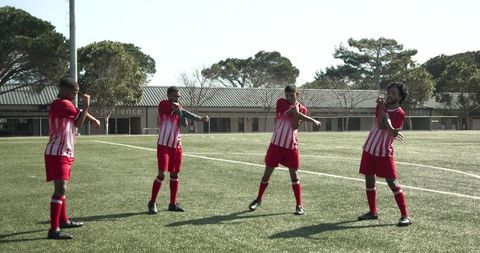 Soccer team warming up on training field with red kits