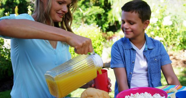 Mother Pouring Juice for Son During Picnic in Park - Download Free Stock Images Pikwizard.com