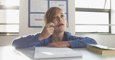 Thoughtful School Boy Engaging in Classroom Writing Activity