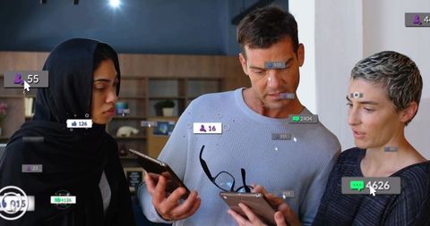 Diverse team examining mobile devices with social media notifications in modern office