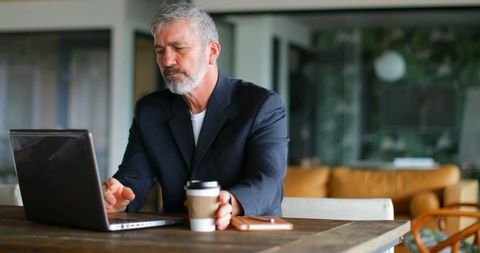 Businessman Focusing on Laptop Work with Coffee in Hand - Download Free Stock Images Pikwizard.com