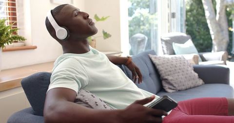 Relaxed Man Enjoying Music on Sofa with Headphones