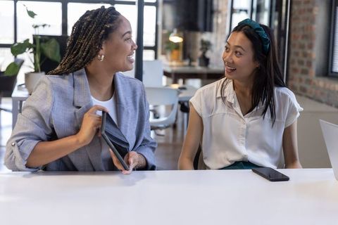 Two Diverse Professionals Collaborating Cheerfully in Modern Workspace