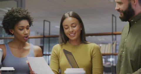 Diverse Colleagues Engaging in Office Discussion Over Documents