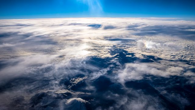 Features awe-inspiring view from above the clouds during the daytime. Perfect for depicting the magnificence of nature, atmospheric phenomena, and travel-related content. Ideal for use in presentations, websites, and environmental projects.