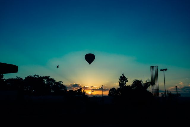 Hot air balloon floating against a vibrant sunset sky, showcasing an adventure travel theme. Ideal for travel promotional materials, blogs, outdoor adventure articles, or inspirational content.