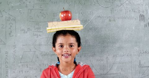 Smiling Student Balances Books on Head in Classroom Setting - Download Free Stock Images Pikwizard.com
