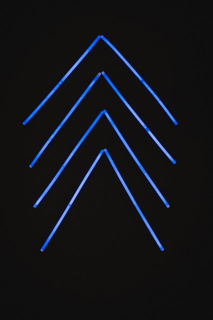 Illustration of illuminated blue neon arrows in a row against black background. Copy space, vector, abstract, glowing, pattern and gradient concept.