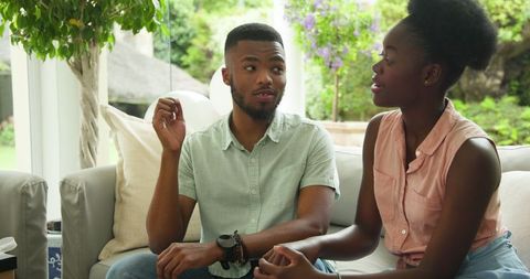 Couple Enjoying Conversation on Sofa at Home