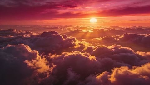 Golden sunset above layered cumulus clouds with radiant sunbeams and violet sky