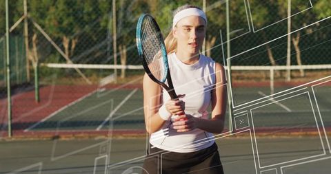 Female tennis player standing on outdoor court gripping racket ready for action, training