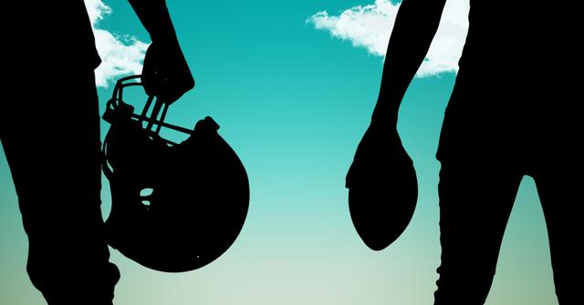 This image captures the silhouette of two American football players holding a helmet and a football against a vibrant blue sky with some clouds. The high contrast between the figures and the background emphasizes the athletic posture and sport gear. This can be used for sports-themed promotions, inspirational posters, team motivation materials, or articles related to American football.