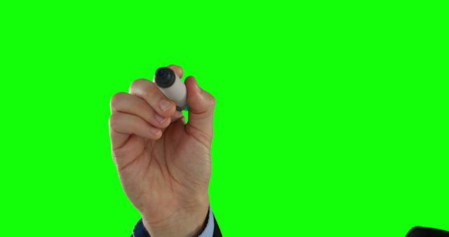 Hand holding a marker writing on a green screen background is ideal for use in presentations, educational videos, and creative projects. Suitable for digital manipulation or overlaying messages and graphics.