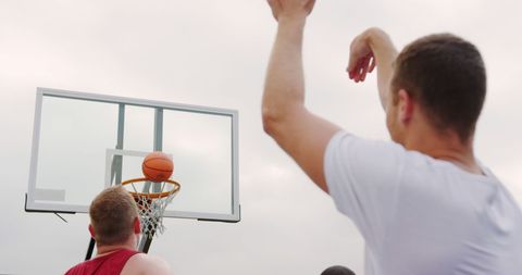 Two Men Engaged in Outdoor Basketball Game