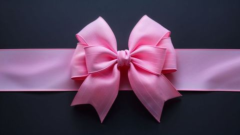 Elegant pink bow on dark surface symbolizes celebration and femininity