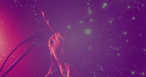 Male Performer Energizing With Microphone in Enchanting Glow