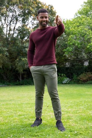 Confident Man in Burgundy Sweater Enjoying Outdoor Lawn
