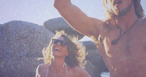 Carefree Couple Celebrating at Rocky Beach