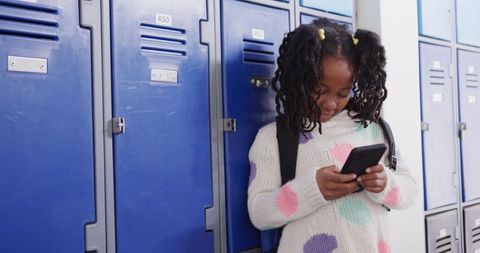 Young Student Checking Smartphone in School Hallway