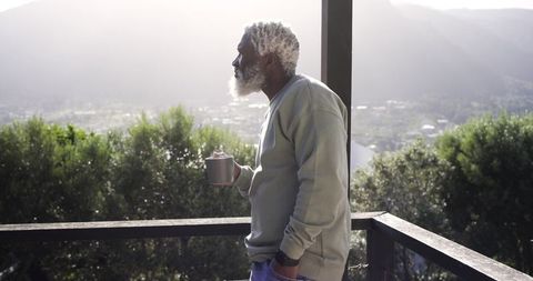 Senior man enjoying morning coffee on scenic balcony relaxation