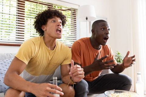Excited Friends Watching Game in Living Room