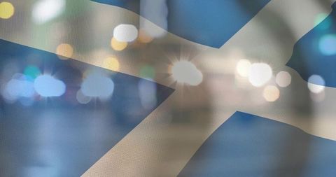 Saltire fabric closeup showing woven texture with bokeh city lights and lens flare at night
