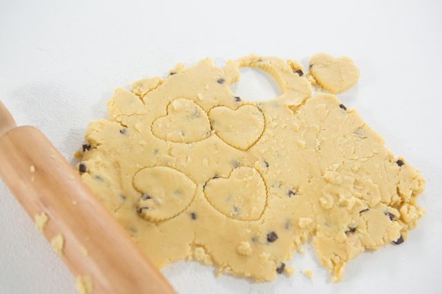 Close-up of rolling pin and cookie dough on white background