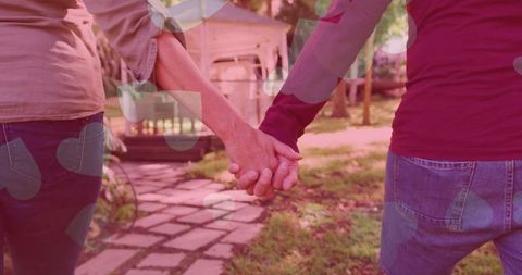 Mature Couple Holding Hands Strolling in Garden Oasis