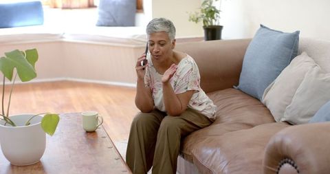 Senior Woman Relaxed on Couch Talking on Smartphone
