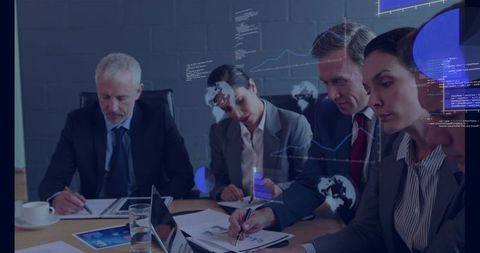 Executive team analyzing financial charts and laptop during strategic boardroom meeting